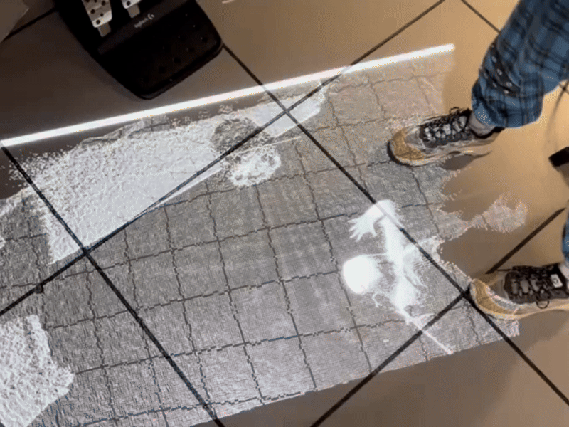 Our group then tested the wispy point cloud visual with the overhead projector in AA1A. 
One challenge I ran into was that since the original visual used the Player Index, the Kinect had a difficult time calculating the silhouette of a person from overhead. I changed the camera input to Colour Point Cloud and adjusted the Threshold to get the visual to appear from the overhead.